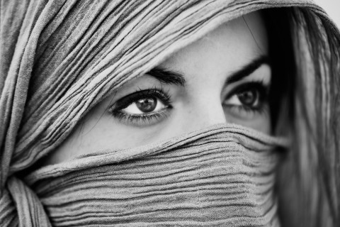 Ojos de una modelo con la cara tapada por una bufanda colocada estilo burka.